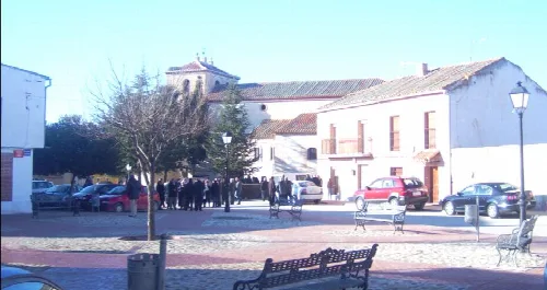 Platz mit Bäumen, Bänken und Menschen in Langa, Ávila.