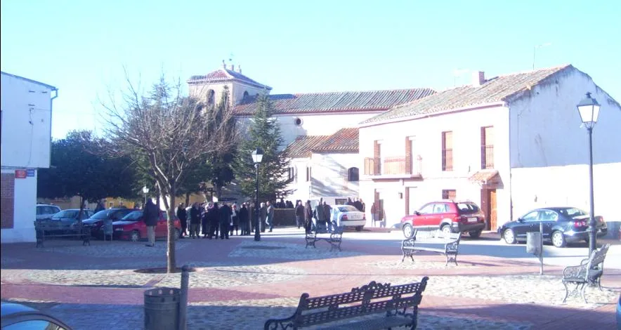 Square with trees, benches, and people in Langa, Ávila.