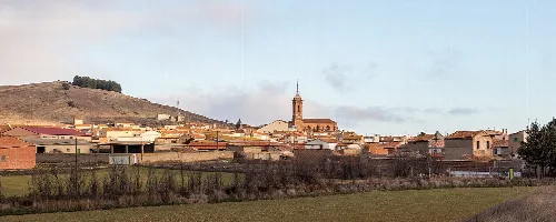 Panoramablick auf Tornos mit Kirche und Häusern am Hügel.