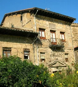 Stone building with iron balcony and sloped roof in Durango.