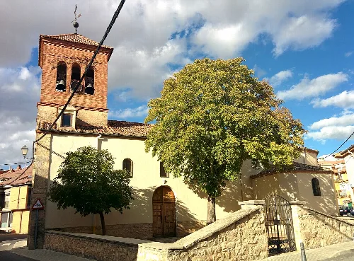 San Juan Bautista church with brick tower and trees in La Lastrilla.