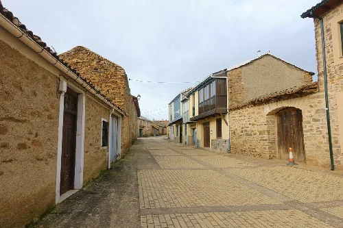 Straße mit traditionellen Häusern und Kopfsteinpflaster in Santa Colomba de Somoza.