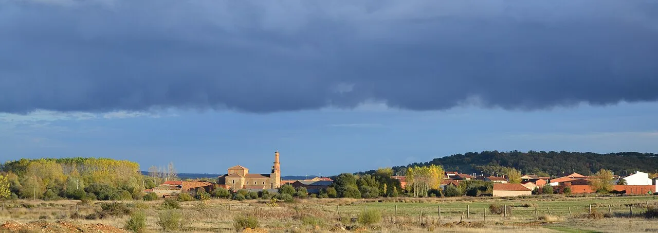 Landschaft mit Kirche und bewölktem Himmel in Quintanilla del Valle, León.