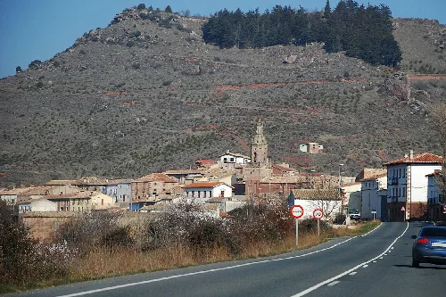 Pueblo de Mués con iglesia y casas tradicionales en un entorno montañoso.