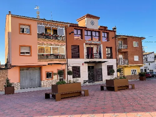 Villar de Olalla Rathaus mit Bänken auf dem Platz.