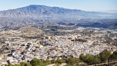 Vista panorámica de Alhama de Almería con montañas y casas blancas.