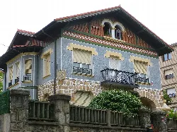 Haus mit blauer Fassade und Stein- und Holzelementen in Sopelana.