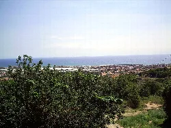Panoramic view of Premià de Mar with sea and town in the background.
