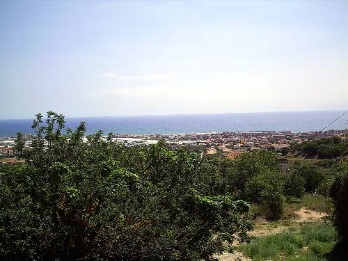 Panoramablick auf Premià de Mar mit Meer und Stadt im Hintergrund.