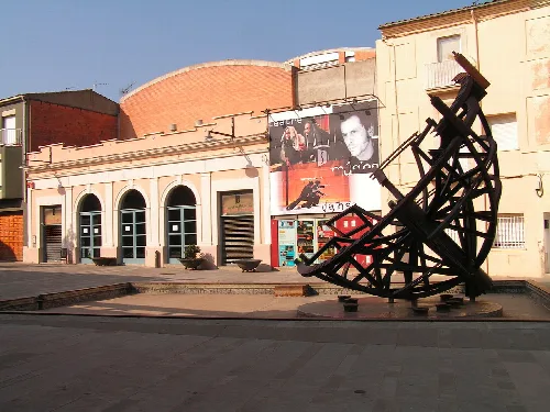 Theatre of Salt, at Plaça Sant Jaume in the city of Salt (Gironès). In the foreground is the sculpture Cúpula invertida (Inverted Cupula, 1997), by Josep Admetlla, with poetry on it by Carles Vivó, Antoni Puigvert and Xavier Otero.