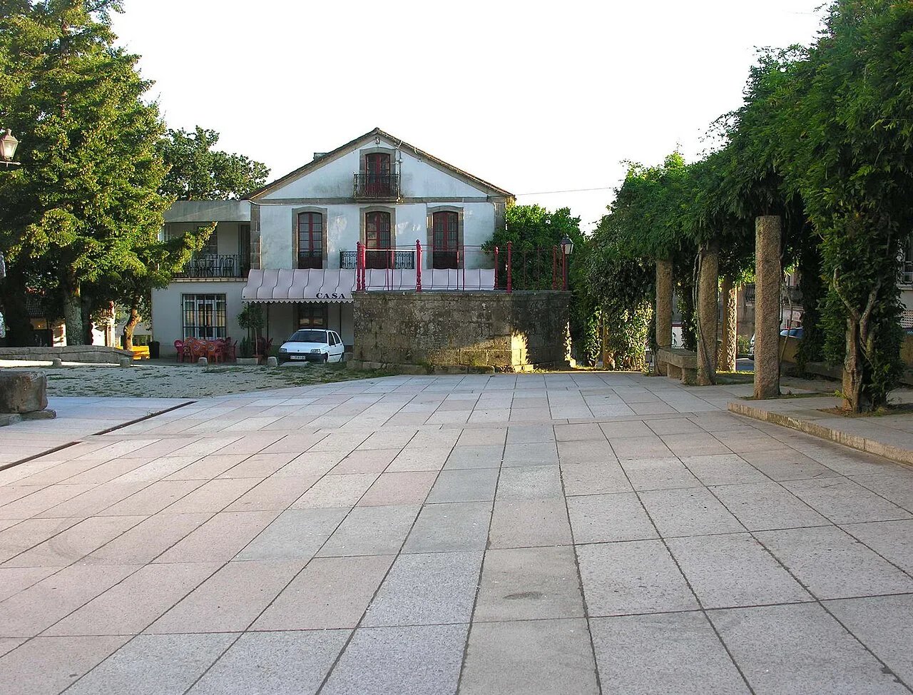 Platz mit Gebäude und Bäumen in Brión, Galicia.