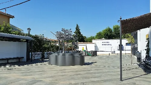 Städtisches Schwimmbad von Malcocinado mit Spielplatz und Schatten.