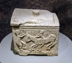 Kalksteinurn mit Szenen von Kämpfen und Pferden, ca. 21 cm lang.