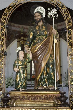 Statue von Heiligem Josef mit einem Kind in einer Kirche.
