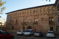 Brick palace facade with windows and balconies in Cascante.