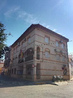 Hellfarbenes Gebäude mit Balkonen und Flaggen an der Fassade.