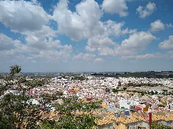 View of Morón de la Frontera with houses and buildings under a cloudy sky.