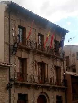 Stone building with balconies and flags in Carcastillo.