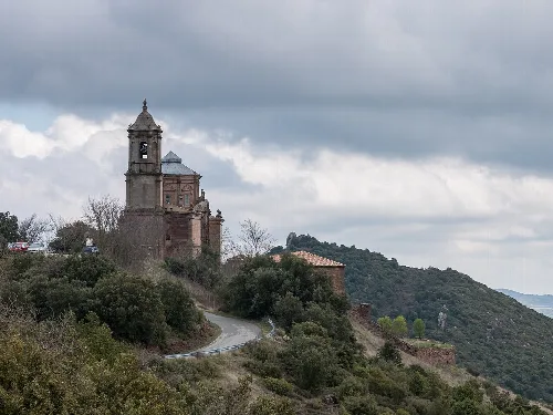 Basílica de San Gregorio Ostiense en Sorlada, Navarra, en una colina con un camino delante.