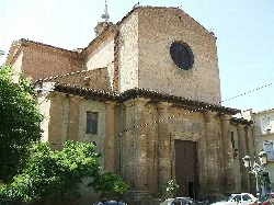 Fachada de la iglesia con columnas y puerta de madera en Sariñena.