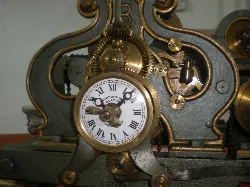 Old clock with gears and Roman numeral dial.