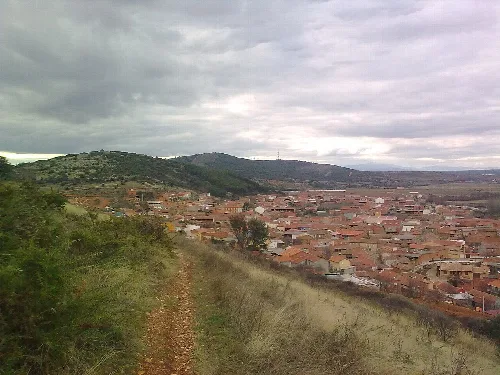 Blick auf eine Stadt mit Häusern und Hügeln an einem bewölkten Tag.
