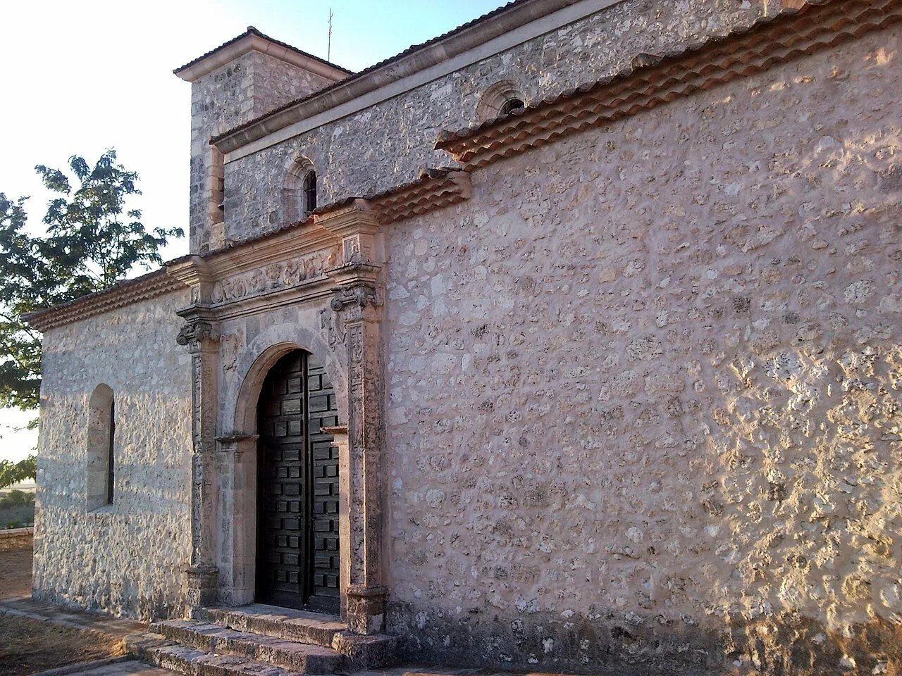 Kirchenfassade mit Holztür und Steinwänden in Calabazas de Fuentidueña.