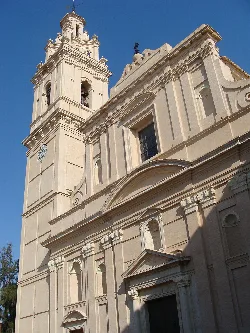 Fachada de una iglesia con torre y detalles arquitectónicos en Valencia.
