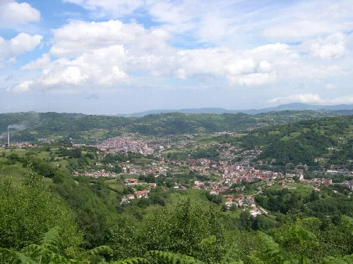 Paisaje del Valle Llangreu con colinas verdes y cielo con nubes.