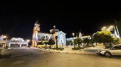Plaza de Valsequillo de Córdoba con árboles, edificios y una torre en la noche.