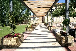 Covered walkway in Concordia Square, Fuentes Claras, with flower pots.