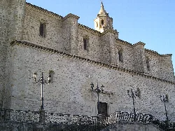 Seitenansicht einer Steinkirche mit Fenstern und Laternen an der Fassade.