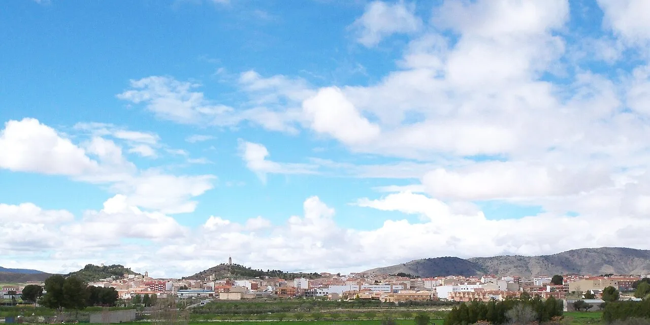 Urban landscape of Tobarra with mountains and blue sky.