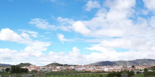 Paisaje urbano de Tobarra con montañas y cielo azul.