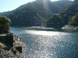Stausee von Salime mit Bergen und grünen Bäumen.