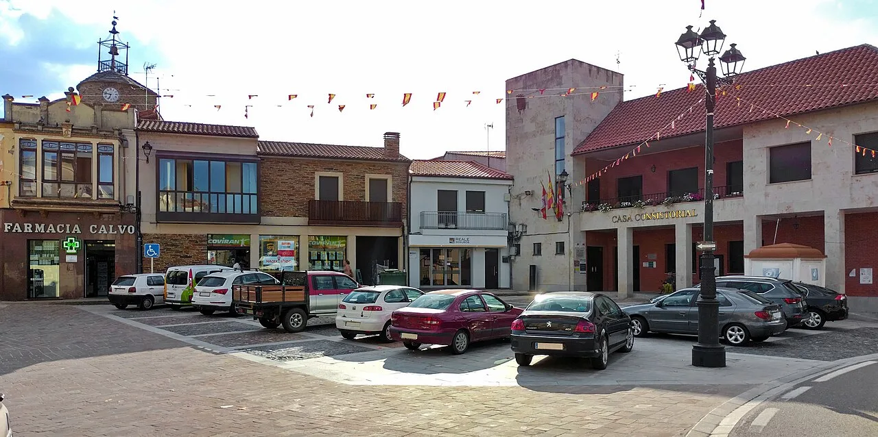 Plaza mayor con edificios y coches estacionados en Alcañices.