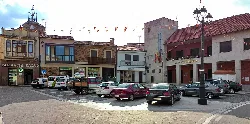 Plaza mayor con edificios y coches estacionados en Alcañices.