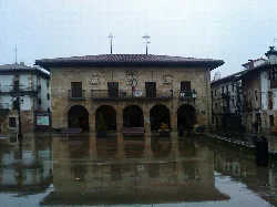 Town hall building in Otxandio with reflection on the rainy square.