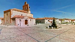 Old church in a square with trees and benches in Martín Muñoz de la Dehesa.