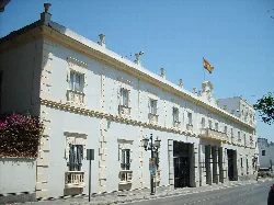 White building with windows and flags in San Fernando.