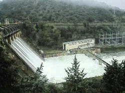 Presa de Cijara con agua en 2013, rodeada de vegetación y estructuras de control.