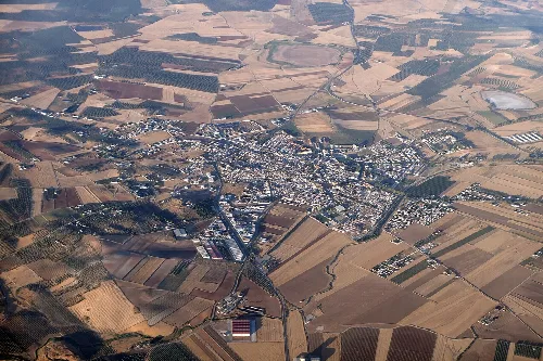 Luftaufnahme einer Stadt inmitten landwirtschaftlicher Felder.