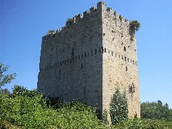 Side view of the Torre de los Velasco with stone walls and battlements.