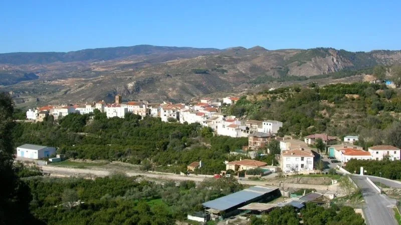Panoramic view of Murchas with white houses and mountains in the background.