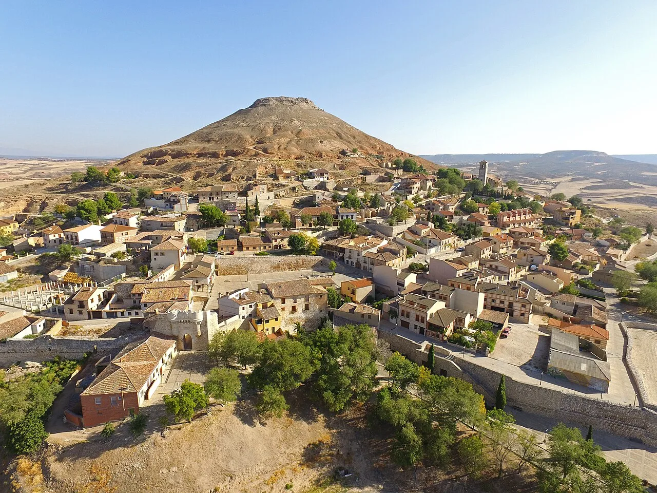 Aerial view of a town with houses and a hill in the background.