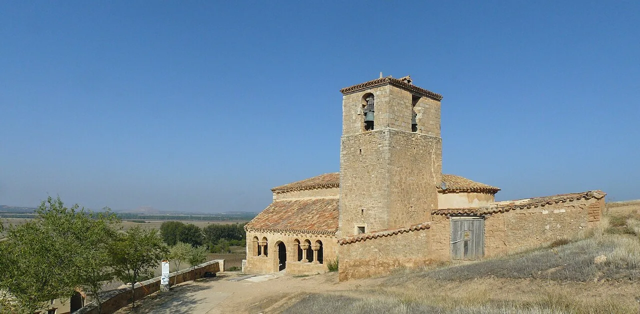 View of the Romanesque church of San Martín, Aguilera, Soria (Spain). At back the huge castle of Gormaz can be seen in the distance.