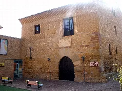 Stone building facade with arched door and windows.