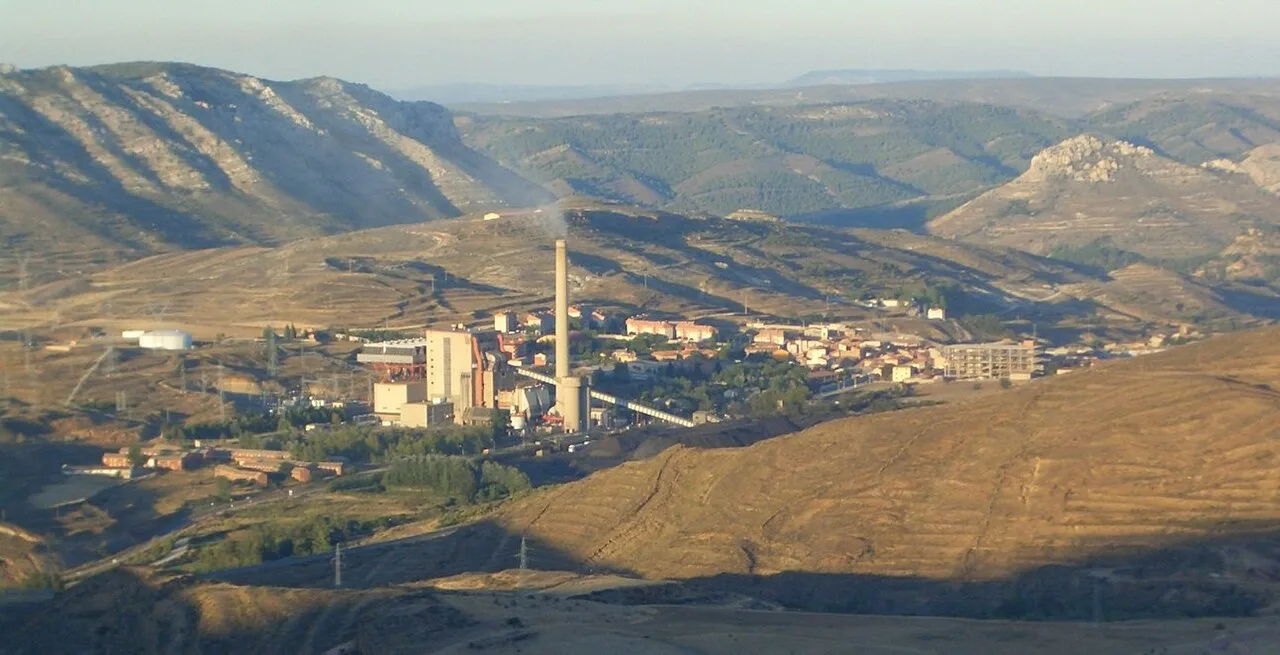 Panoramic view of a town in the mountains with factories and hills.