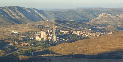 Panoramablick auf eine Stadt in den Bergen mit Fabriken und Hügeln.