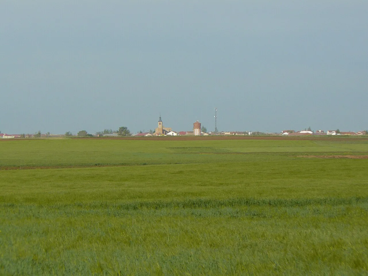 Ländliche Landschaft mit Kirche und Gebäuden in Villarramiel, Palencia.